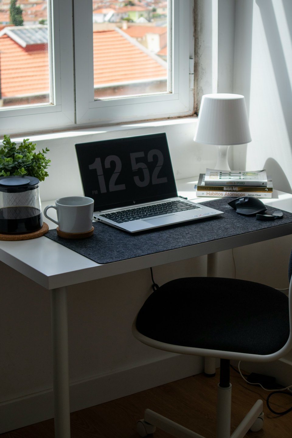 Modern home office desk with laptop, mug, and plant.
